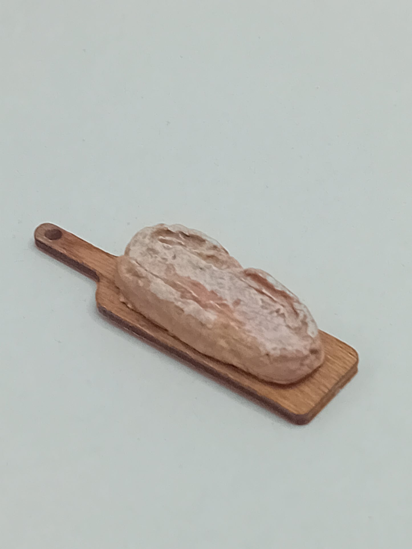 1:12 scale Polymer clay Rustic large farmhouse style sourdough loaf on a bread board.