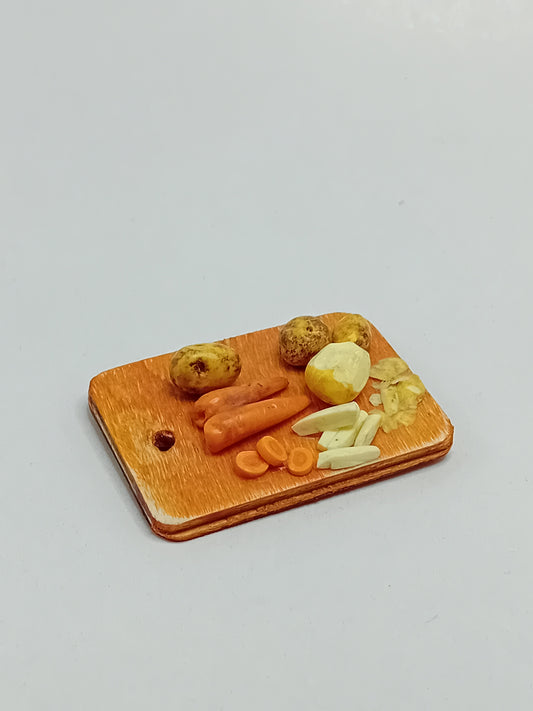 1:12 scale polymer clay Carrots, potatoes peeled and chipped on a wooden rustic farmhouse style hanging chopping board.
