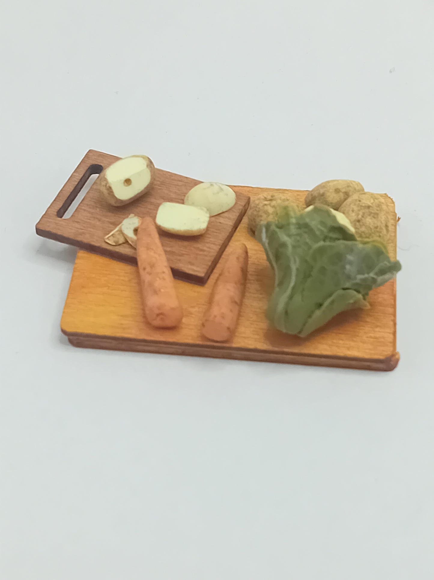 1:12 scale cauliflower, carrots and potatoes peeled on a chopping board placed on wooden display board 5cm x 4cm.